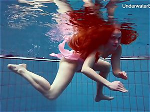 ginger-haired Simonna showcasing her assets underwater